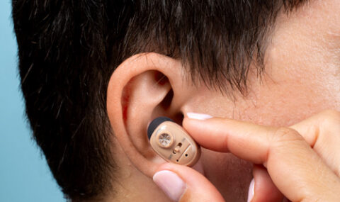 a man putting a hearing aid Best hearing aids